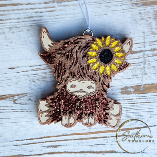 adorable highland cow shaped vehicle air freshener decorated with brown glitter and a sunflower in yellow and black