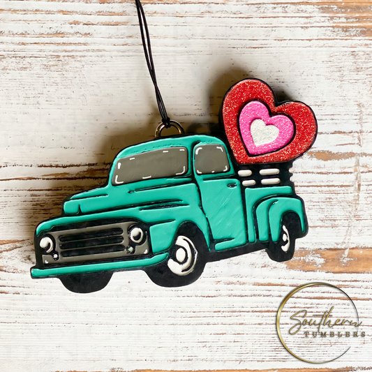 old truck shaped car air freshener caring a heart