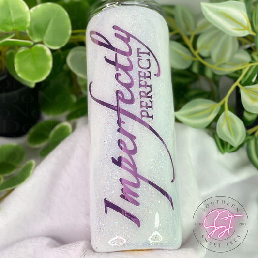 20oz skinny straight tumbler decorated with shades of white glitter with a milky way effect saying imperfectly perfect in purple vinyl 