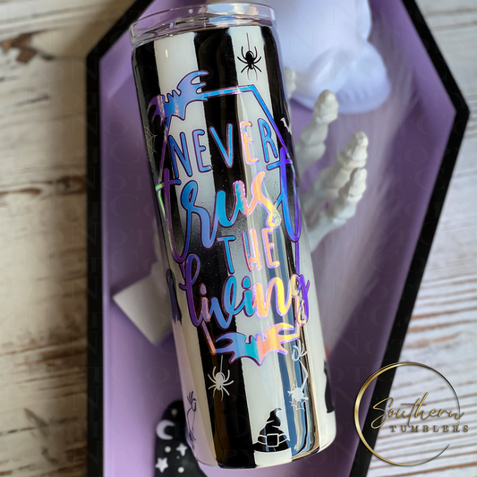 20oz skinny tumbler painted half black and half white decorated with bats, spiders, and cats saying never trust the living which also glows in the dark