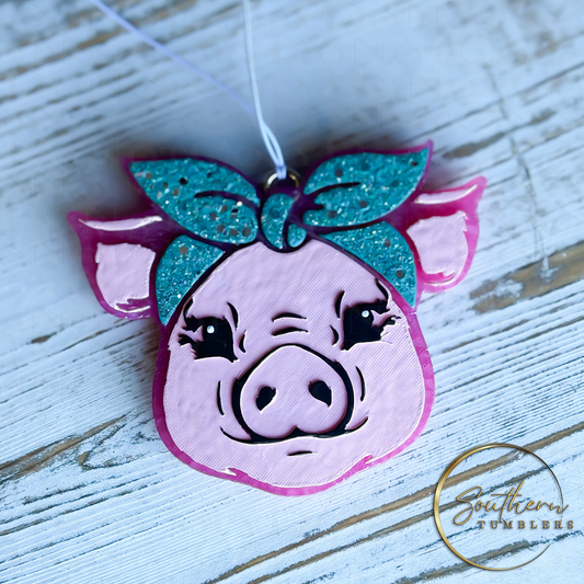 pig shaped car air freshener decorated with a glitter bow