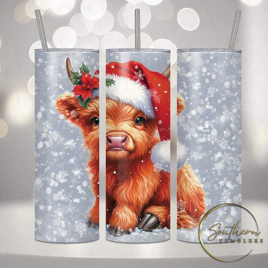 20oz stainless steel sublimated tumbler decorated with a baby highland cow wearing a santa hat in a snow field