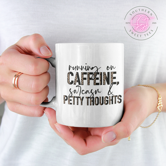 11oz white drinking mug for coffee, tea or hot chocolate with a sarcastic saying running on caffeine, sarcasm and petty thoughts which include cheetah prints