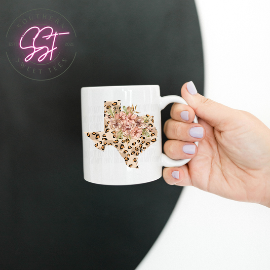 11oz white colored ceramic drinking mug with the image of Texas state in leopard print and a bundle of beautiful flowers 