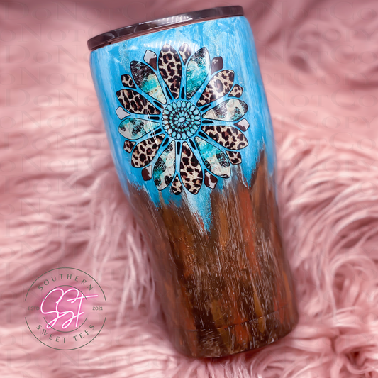 20oz modern curved tumbler decorated with brown red and teal paints to have a old western patina look with a sunflower leopard print decal